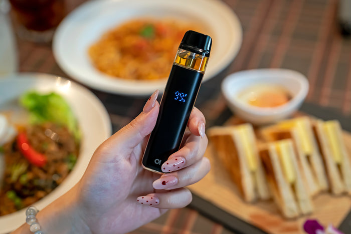 Person holding Aspire Loomix device with battery percentage showing