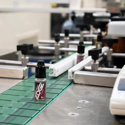 E-liquid bottles on a production line with blurred background