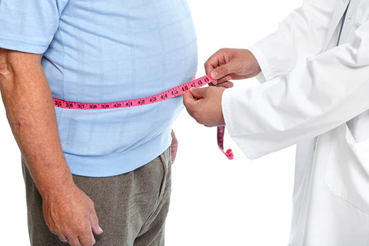 Person being measured with a tape measure by a medical professional on a white background